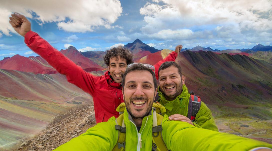 Projects Abroad volunteers discover how travel changed them in 2020. Travellers take a selfie with the Rainbow Mountains of Peru in the background.